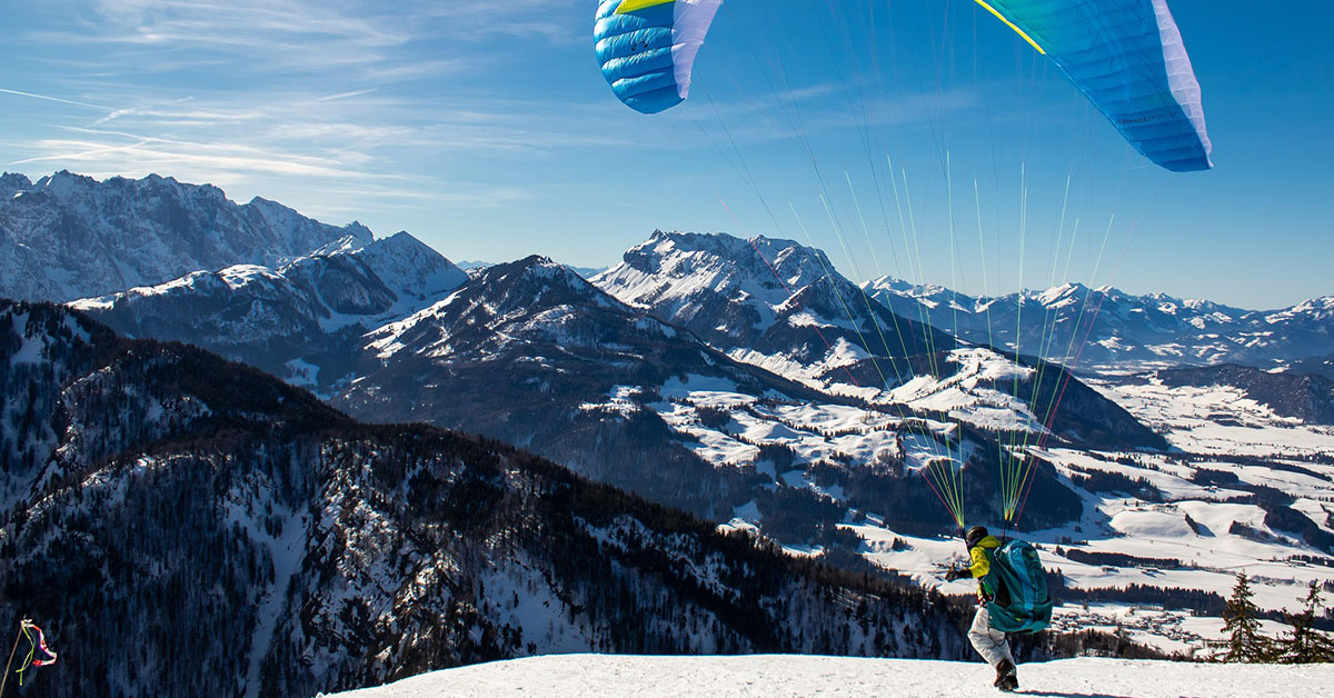 Ein Paraglider beim Start auf einer Bergkuppe